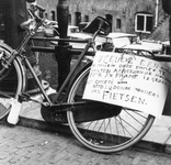 603862 Afbeelding van een fiets tegen de balustrade van de Oudegracht te Utrecht, met een bord met het opschrift: U ...